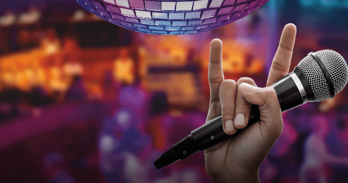 Man holding karaoke mic in front of disco ball